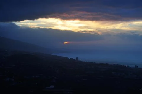 The sun through the clouds at dusk Stock Photos