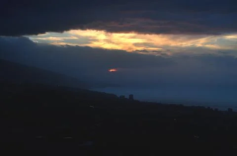 The sun through the clouds at dusk Stock Photos