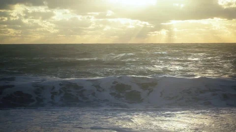 The sun through the clouds illuminates the storm on the sea Stock Footage 82319033