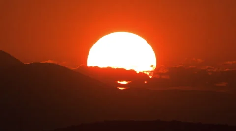 Sun tracking scenic sunset timelapse behind hills Stock Footage