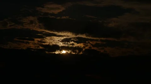 The sun tries to break its rays through the floating, dark clouds Stock Footage 273588691
