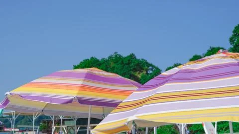 Sun umbrella on the pebble beach. Stock Photos