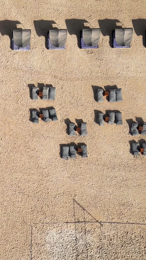 Sun umbrellas at the empty beach at morning time, Drone point of view.Vertical v Stock Footage 311942946