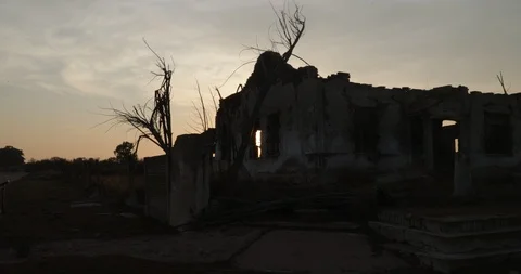 Sun with volume light appearing behind silhuettes of destructed city Видео 126322502