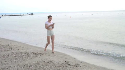 Sunbather girl wearing bikini using a smart phone on summer holidays on the Stock Footage 64047052
