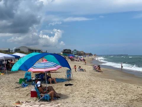 Sunbathers with umbrellas on the beach  Stock Photos