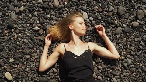 Sunbathing on black pebbles 스톡 동영상 106060989