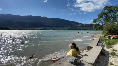 Sunbathing in mountain lake Annecy Stock Footage 247154889