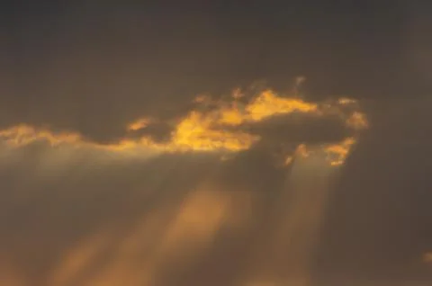 Sunbeam behind clouds Stock Photos