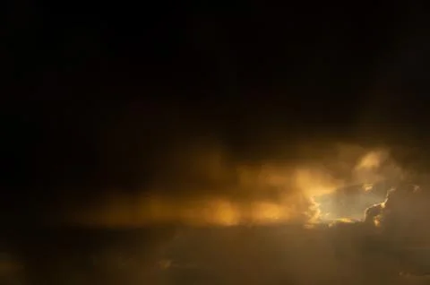 Sunbeam behind clouds Stock Photos