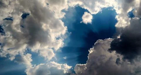 Sunbeam behind dark clouds Stock Photos