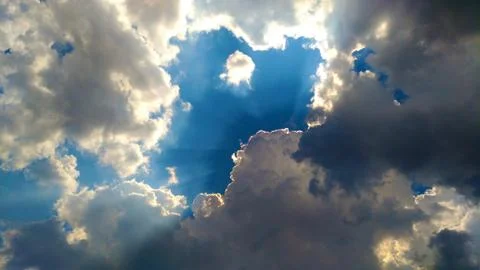 Sunbeam behind dark clouds Stock Photos