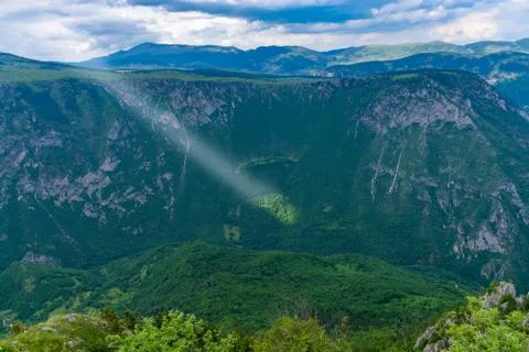 The sunbeam makes its way through the clouds to the mountainside. Foto stock