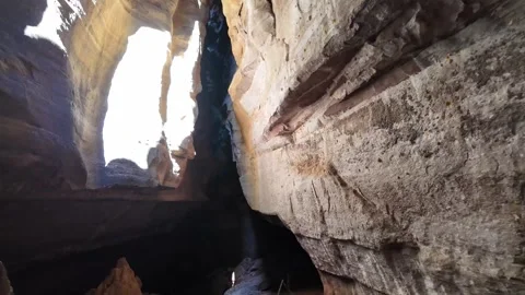 Sunbeam shines through cave opening illuminating dark rock chamber in Serra da Video stock 346132220