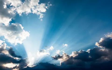 Sunbeams from behind the clouds Stock Photos