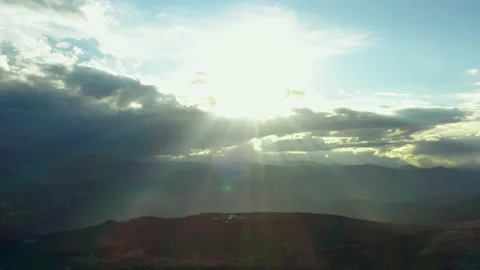 Sunbeams break through clouds above mountain peaks Stock Footage 167857451