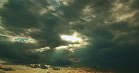 The sunbeams break through dense gray cumulus moving clouds, time lapse Stock Footage 204780139