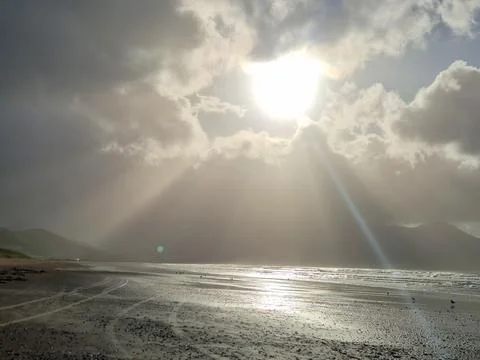 Sunbeams Breaking Through Clouds Over Beach Stock Photos