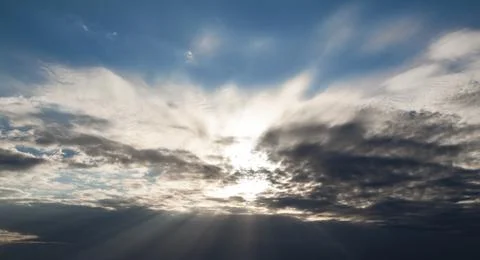 Sunbeams breaking through the dark clouds. Only sky, no land. Stock Photos