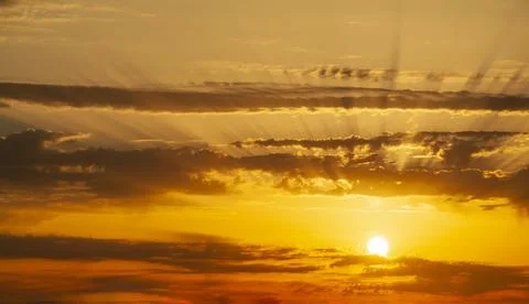 Sunbeams breaking through the dark clouds at sunset. Only sky, no land. Stock Photos