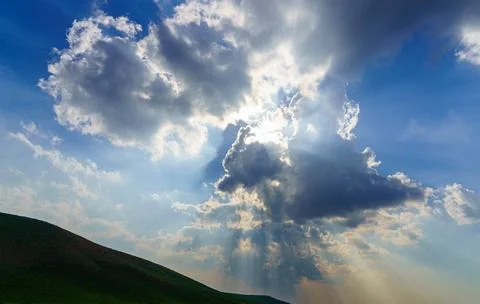 Sunbeams breaking through dramatic cumulus clouds. Change of weather. Hope .. Stock Photos