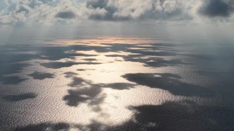 Sunbeams cut through clouds above the calm ocean Video stock 337729548