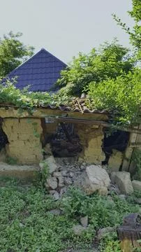 Sunbeams filter through a ruined, collapsing traditional mudbrick house Foto stock