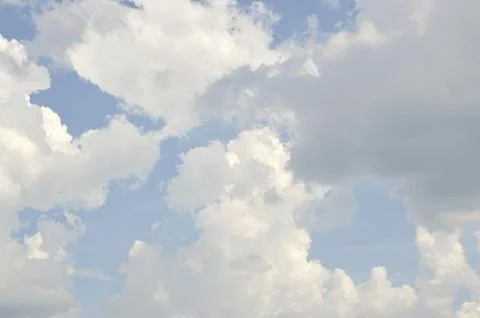 Sunbeams or light beams breaking through the clouds on a blue sky during sunset Stock Photos