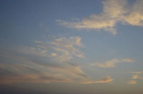 Sunbeams or light beams breaking through the clouds on a blue sky during sunset Stock Photos