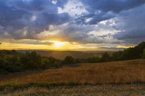 Sunbeams piercing dramatic clouds over Provence landscape Stock Photos
