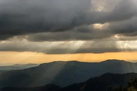 Sunbeams Piercing Through Dark Storm Clouds Over Kerala Mountains Stock Photos