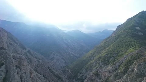 Sunbeams pour through a deep Iranian mountain canyon, light shafts crossing Stock Photos