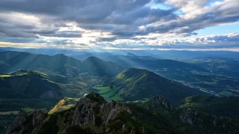Sunbeams shine through moving clouds at sunset. Rays illuminate the idyllic Video stock 284759915