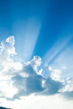 Sunbeams shines through the cloud over a mountain. Stock Photos