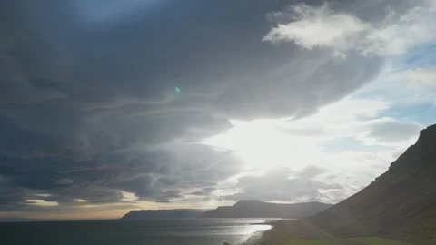 Sunbeams shining through dramatic clouds over a beach and mountains in Iceland. Stock Footage 293088631