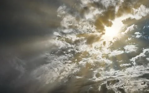 Sunbeams shining through dramatic storm clouds at sunset with dramatic ligh.. 写真素材
