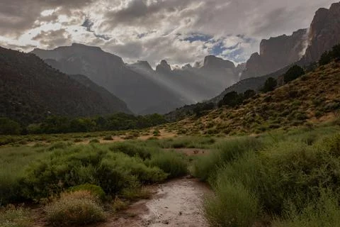 Sunbeams slant down from breaks in the cloud in Zion park Utah Stock Photos