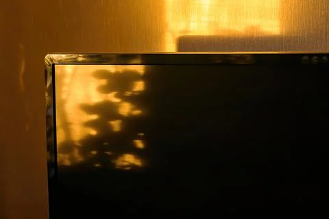 Sunbeams at sunset fall on computer desk in apartment. Stock Photos