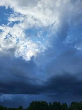 Sunbeams through a gap in dark storm clouds, climate contrasts of the atmosphere 스톡 사진