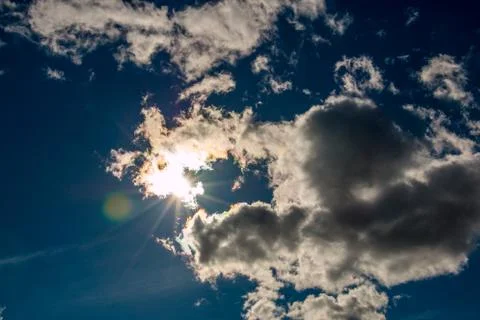 Sunbeams through the white clouds and deep blue sky 库存照片