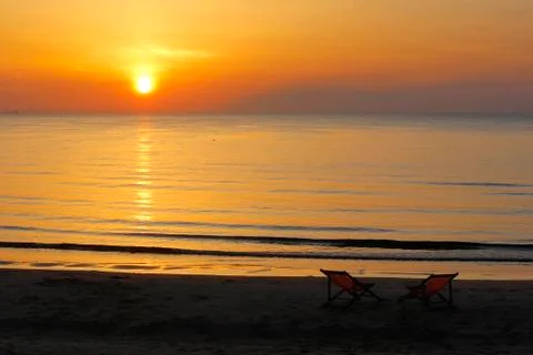 Sunbed on the beach with sunrise background Stock Photos