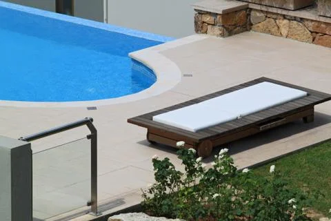 Sunbed for relaxation next to the pool Stock Photos