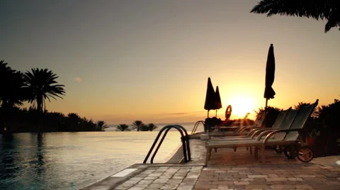 Sunbeds by the infinity pool at the sunrise Stock Footage 1085455