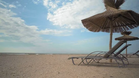 Sunbeds Stand under the straw umbrellas on the Sea Beach Stock Footage 95051852