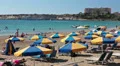Sunbeds under parasols with sunbathing people, Coral Bay, Peyia, Paphos, Cyprus HD Footage