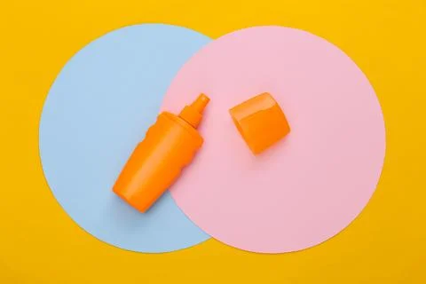 Sunblock bottle on colored background. Top view 库存照片