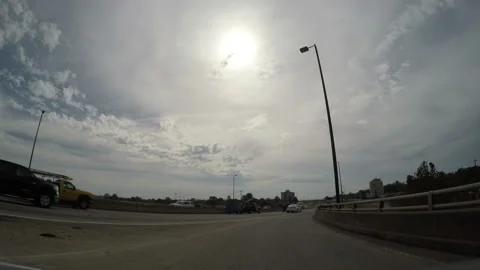 Sunburst behind thin clouds above a curving motorway Stock Footage 153355958