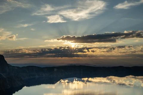 Sunburst Breaks Through Dark Clouds Over Crater Lake Just After Sun Rise Photos