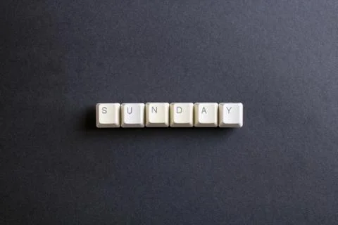 Sunday word on computer keys button on dark background. Stock Photos