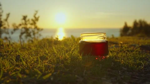 Sundown delight with refreshing drink by the lakeshore Stock Footage 296188337